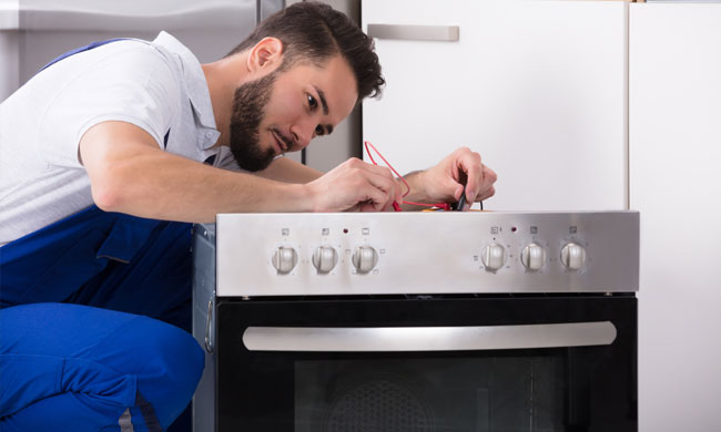 man fixing an oven